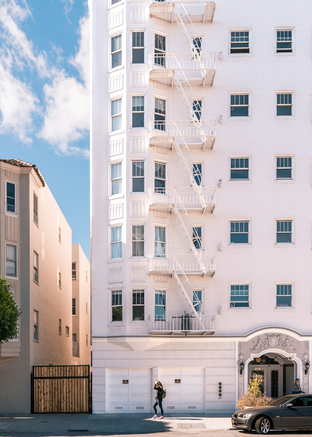 Pessoa em pé perto do edifício branco durante o dia