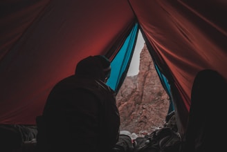person in red and blue camping tent
