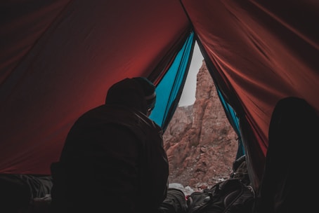 person in red and blue camping tent