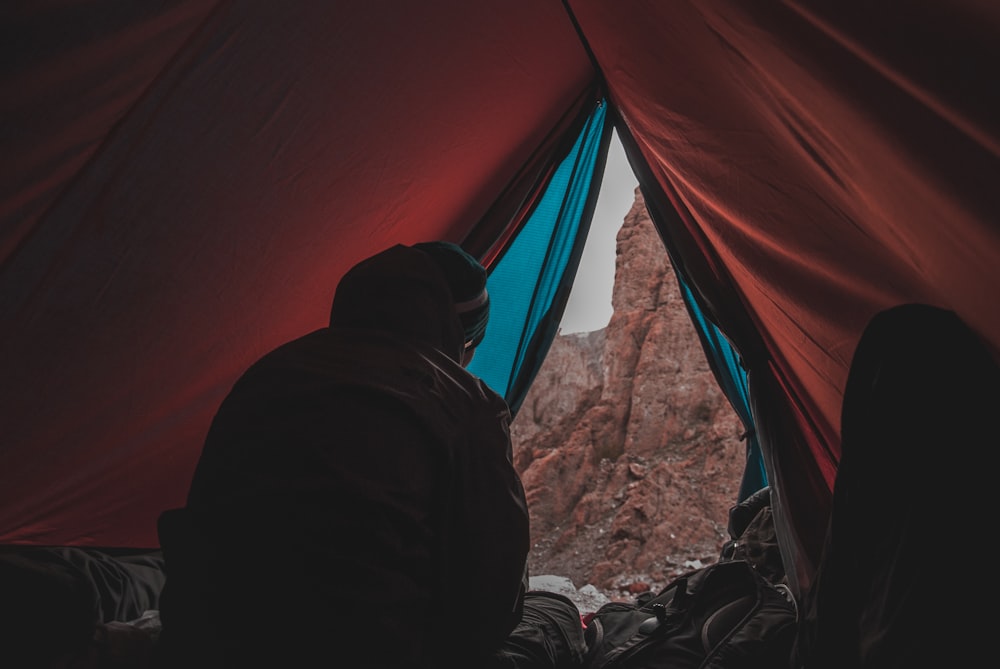 person in red and blue camping tent
