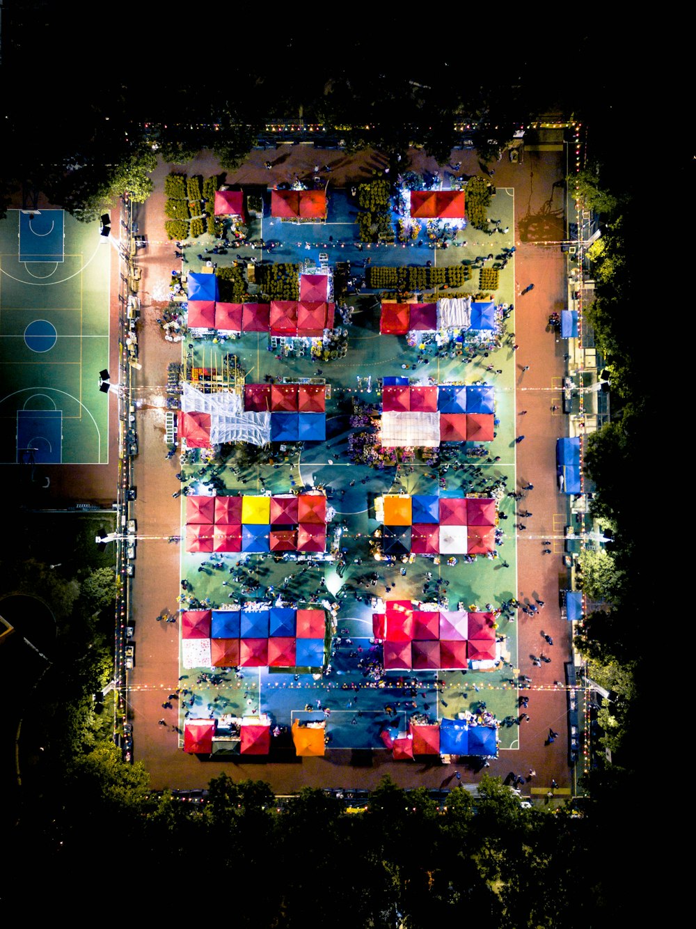 Luftaufnahme des Spielfeldes mit Sonnenschirmen in der Nähe des Basketballplatzes bei Tag