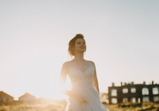 woman in white spaghetti strap dress smiling during daytime