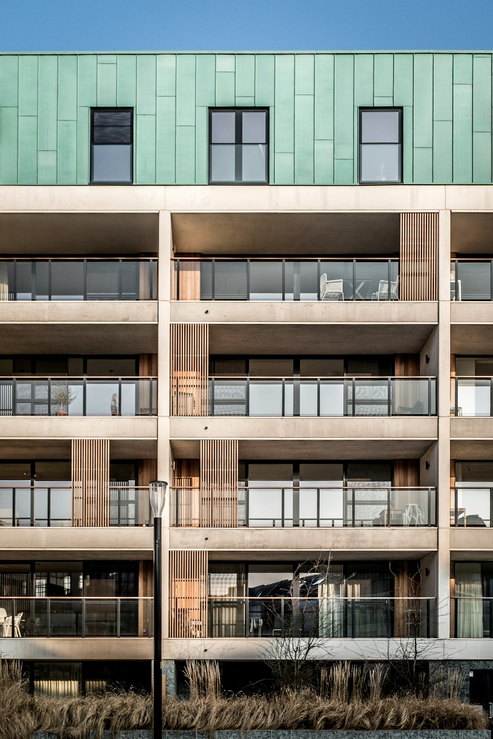 Bâtiment brun et vert de 5 étages pendant la journée