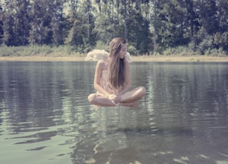 woman floating above body of water