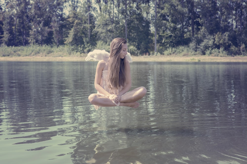 woman floating above body of water