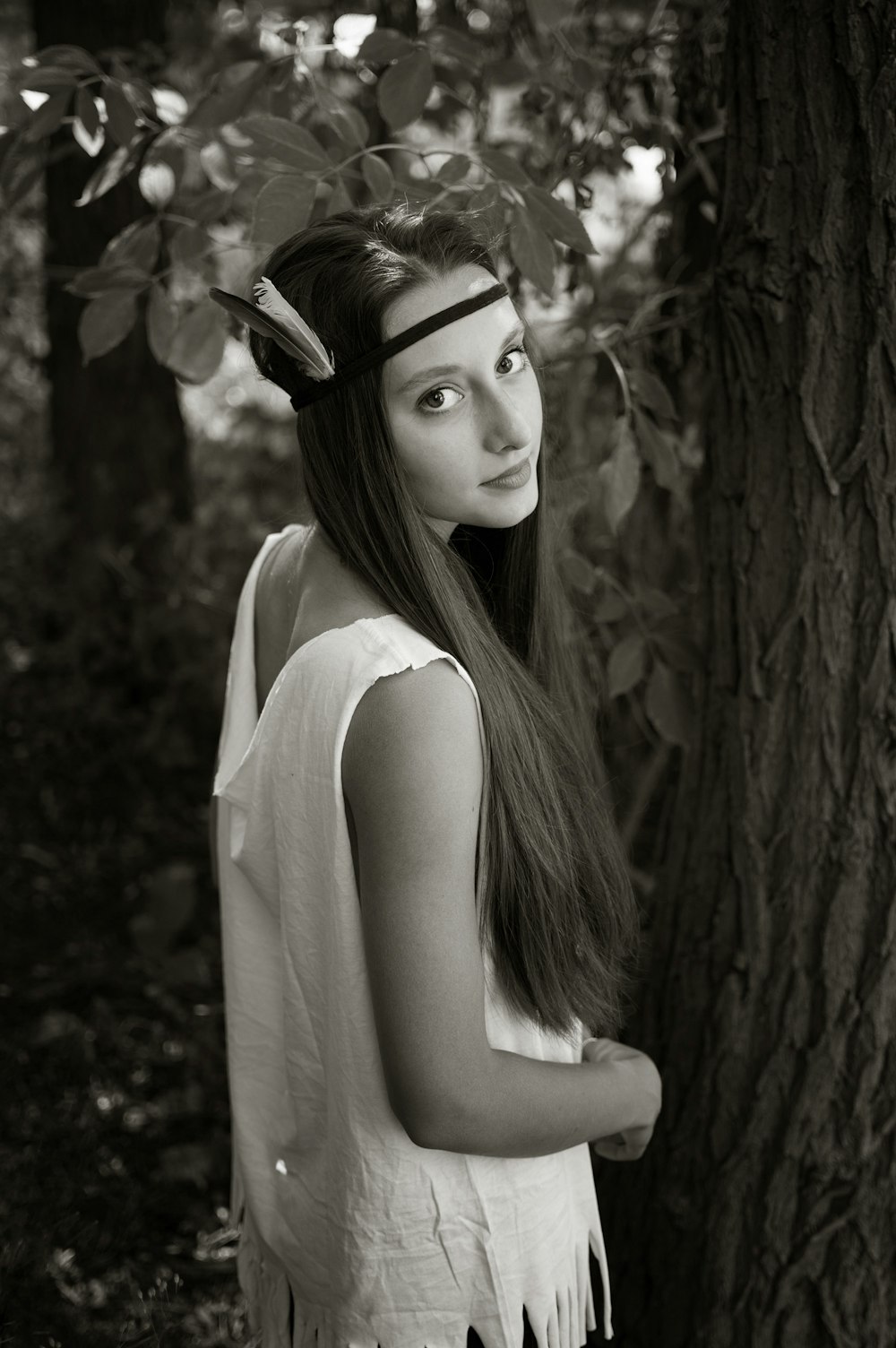 grayscale photo of woman near tree