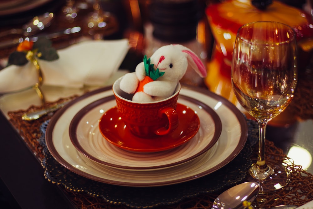 white and red ceramic teacup on saucer