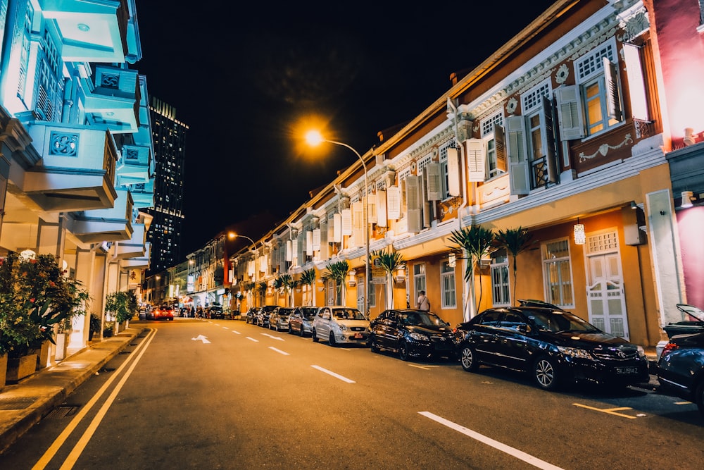 assorted-color vehicle park near high-rise building at night