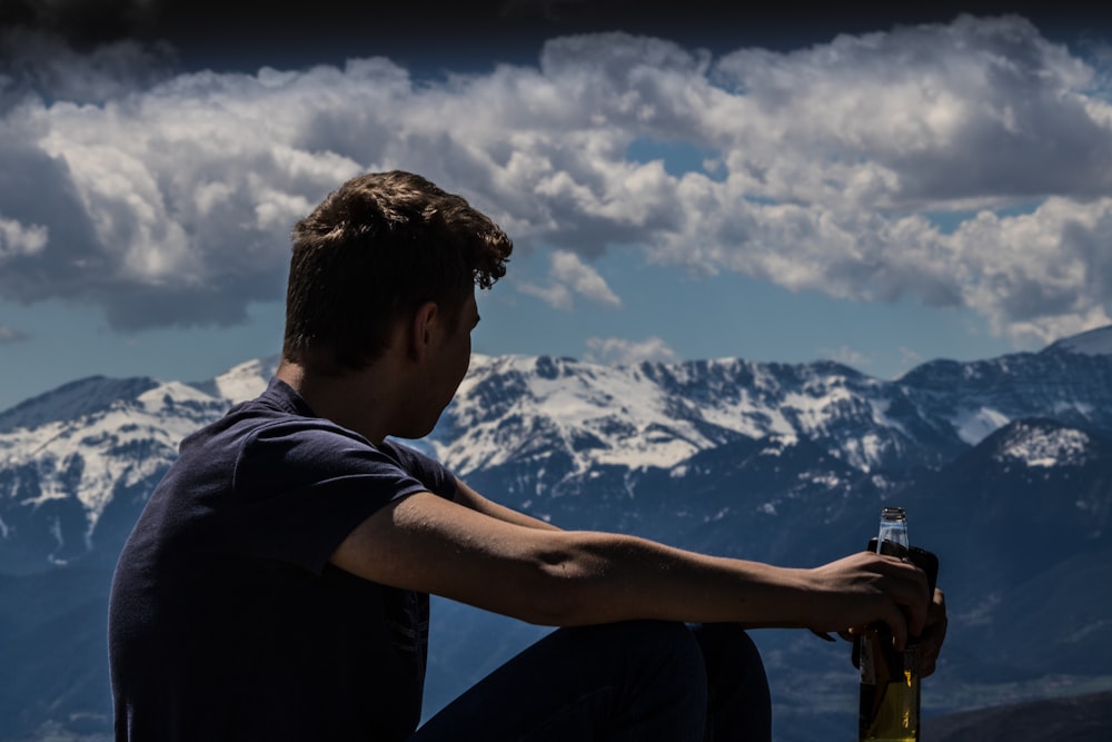 uomo che tiene la bottiglia di birra