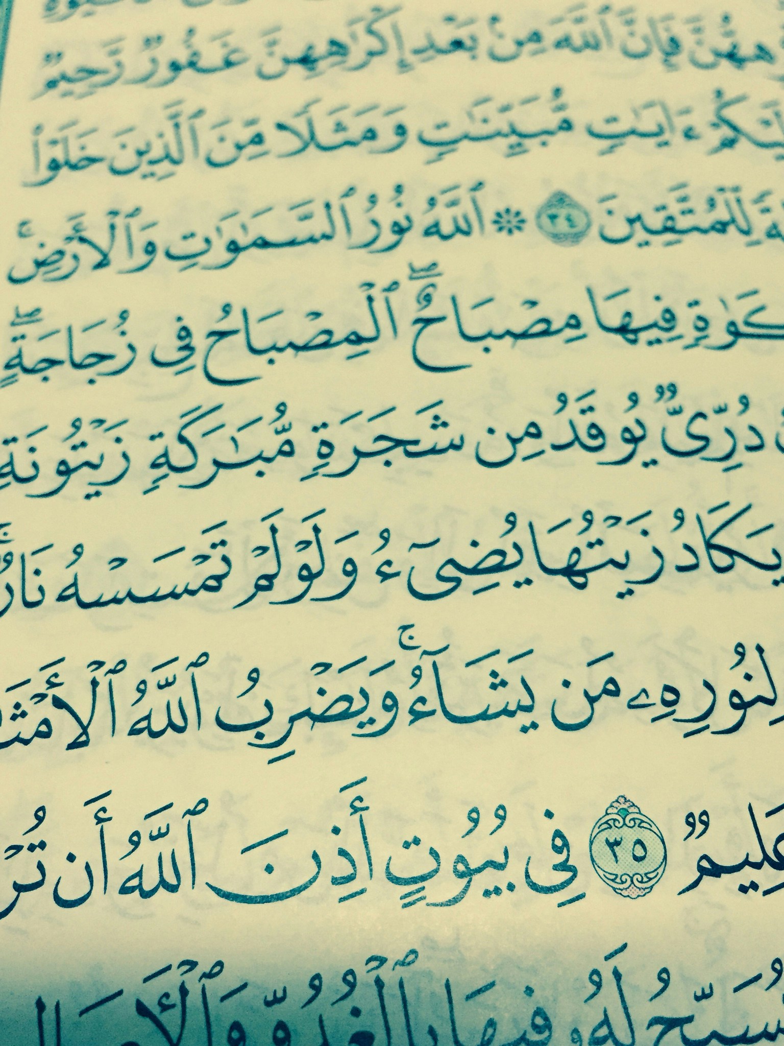 Close-up of Arabic calligraphy text in Quran, gold ink on aged parchment