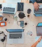 people sitting down near table with assorted laptop computers