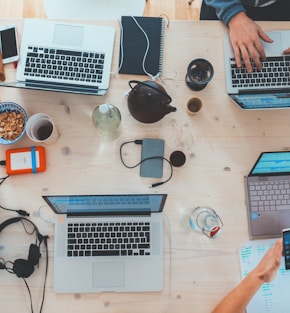 people sitting down near table with assorted laptop computers