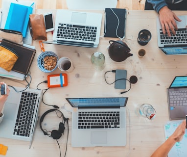 people sitting down near table with assorted laptop computers