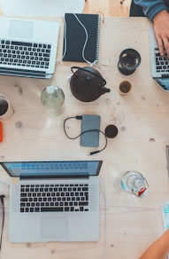 people sitting down near table with assorted laptop computers