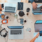 people sitting down near table with assorted laptop computers