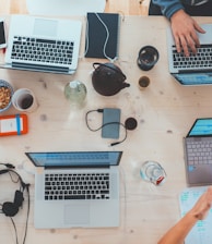 people sitting down near table with assorted laptop computers