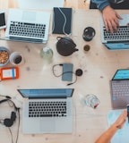 people sitting down near table with assorted laptop computers