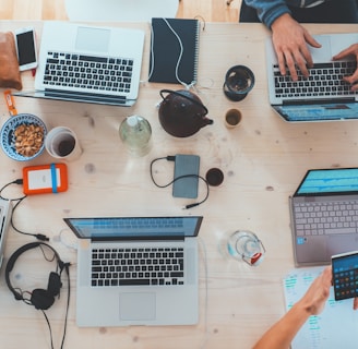 people sitting down near table with assorted laptop computers