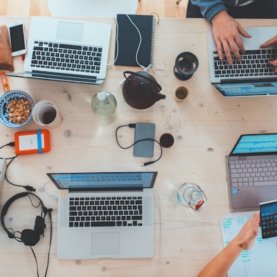 people sitting down near table with assorted laptop computers