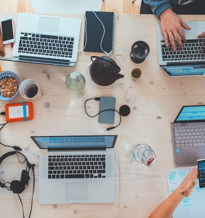 people sitting down near table with assorted laptop computers