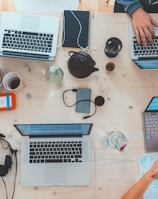 people sitting down near table with assorted laptop computers