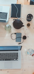 people sitting down near table with assorted laptop computers