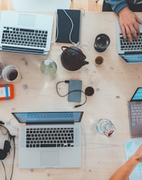 people sitting down near table with assorted laptop computers