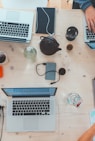 people sitting down near table with assorted laptop computers