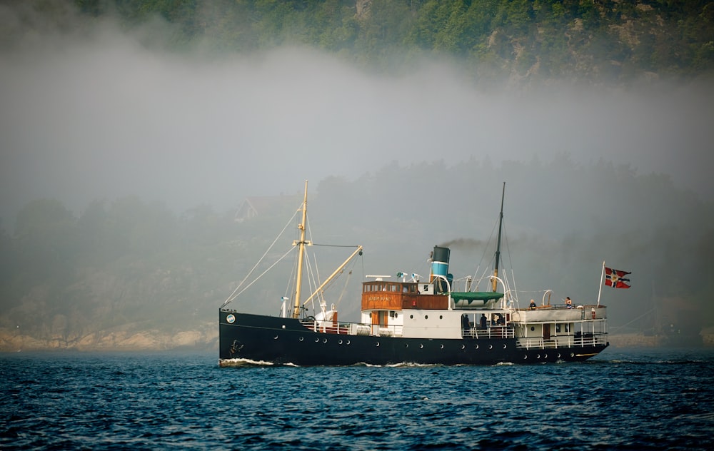 black and white ship on sea under cloudy sky during daytime