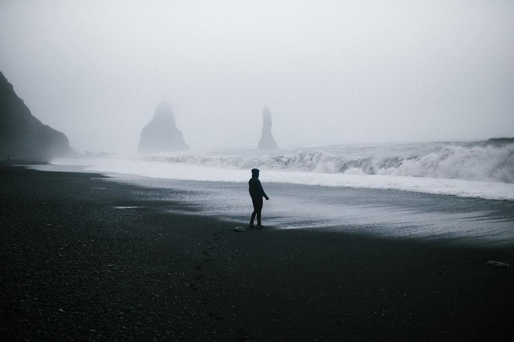 silhouette of man waking on shore