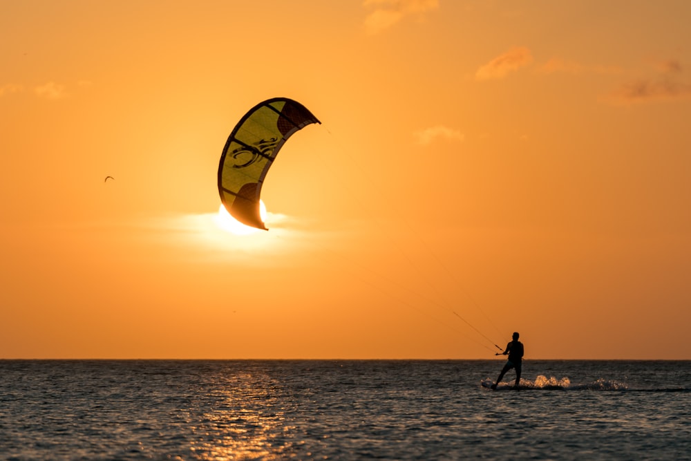 homme surfant au coucher du soleil