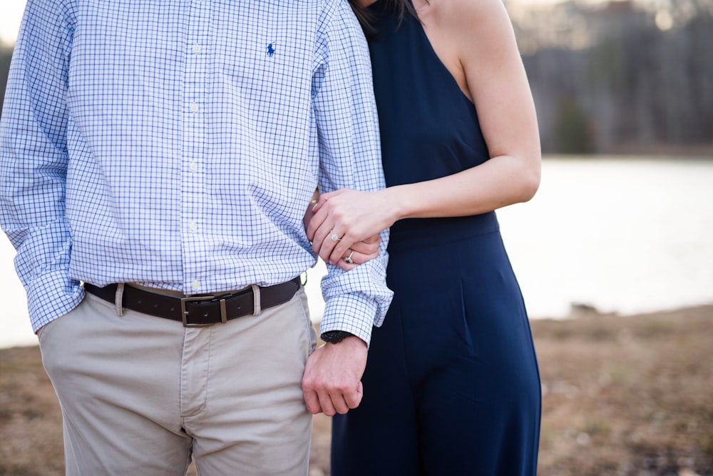 man and woman standing near body of water