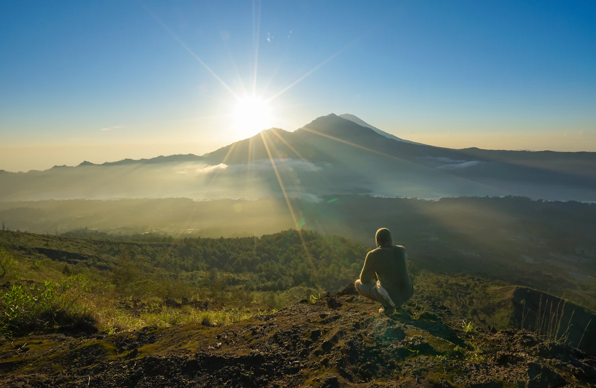 Sunrise breaking over the volcanic caldera and volcanic peak of Mount Batur