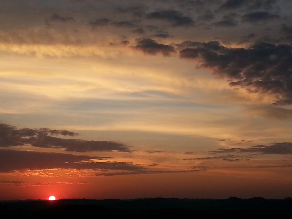 sunrise under cloudy sky