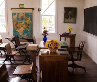 vacant white painted classroom with chairs, tables , and map on the wall