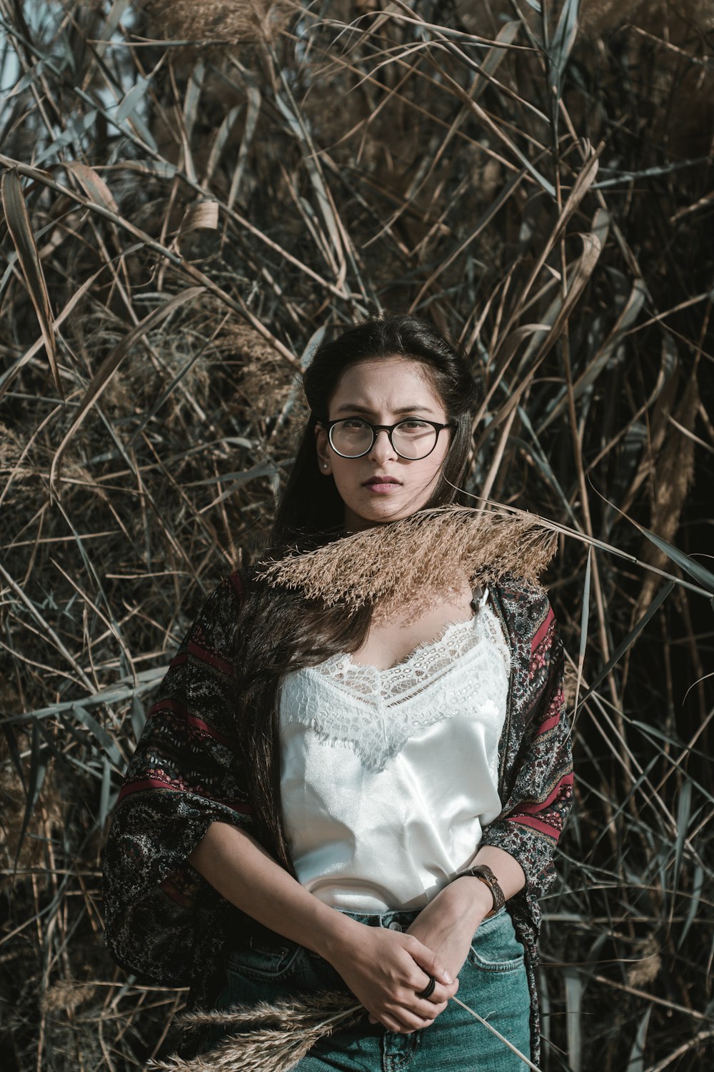 Mujer de pie junto a las plantas de bambú