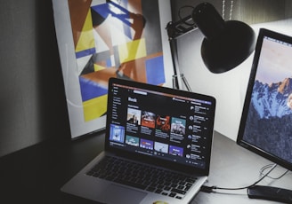 turned on MacBook on table beside iMac