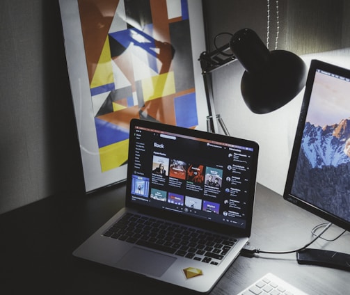 turned on MacBook on table beside iMac