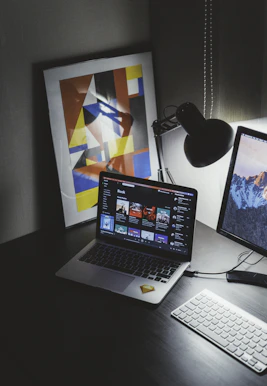 A vibrant Afro-modern digital workspace with music and books displayed on screens.