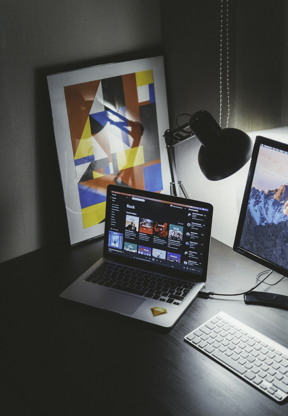 turned on MacBook on table beside iMac