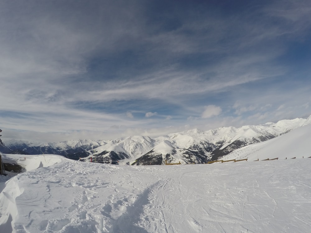 snow covered mountains under cloudy sky