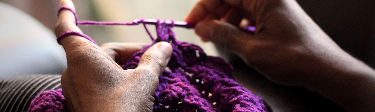 woman sewing purple textile