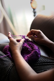 woman sewing purple textile