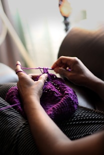woman sewing purple textile