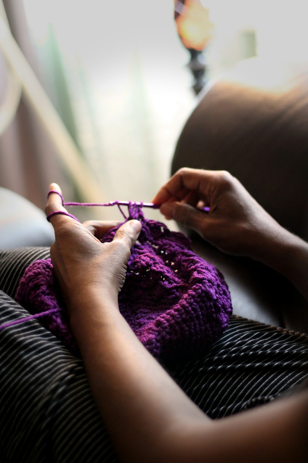 紫色のテキスタイルを縫う女性
