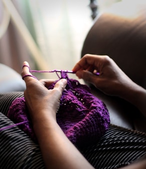woman sewing purple textile