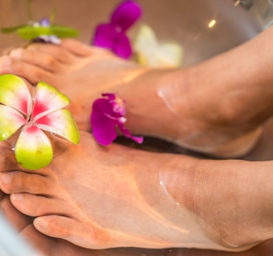 person's feet with flowers