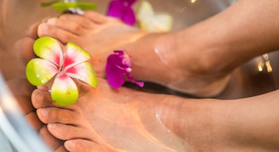 person's feet with flowers