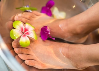 person's feet with flowers