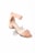 A stylish, peach-colored suede sandal with a block heel and ankle strap. The design features a unique scalloped edge on the strap, and the shoe has a modern, minimalist aesthetic.